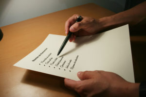 Hands holding a paper and pencil