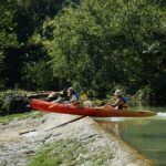 A kayak balances on the edge of a barrier